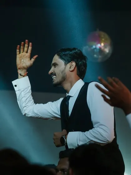 The groom celebrating with his friends on the dance floor during the Sangeet night, full of energy and happiness.