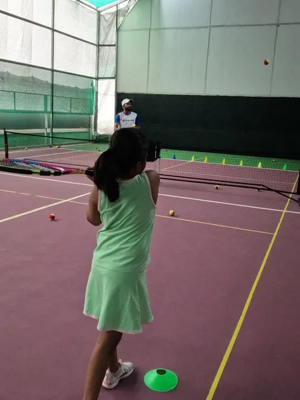 A young player in our Red Batch practices her swing during a drill. We break down the fundamentals of tennis into simple, engaging steps for our youngest students.