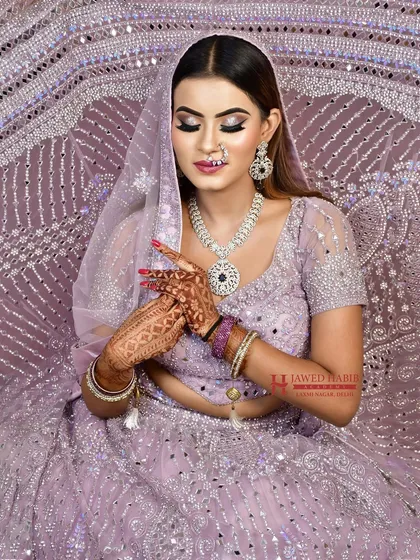 A serene portrait of the bride in a lavender ensemble, with soft, shimmering eye makeup. This look is perfect for evening receptions and cocktail events.
