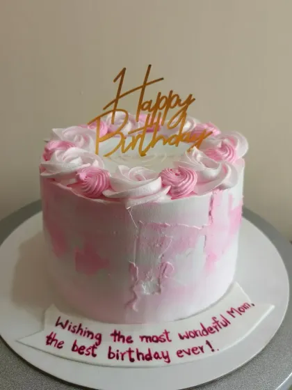 A pretty pink and white cake for a mom's birthday, with piped rosettes.