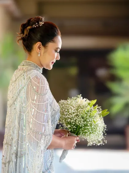 A stunning portrait of the wife on her silver wedding anniversary. She looks absolutely elegant and radiant, holding a beautiful bouquet.