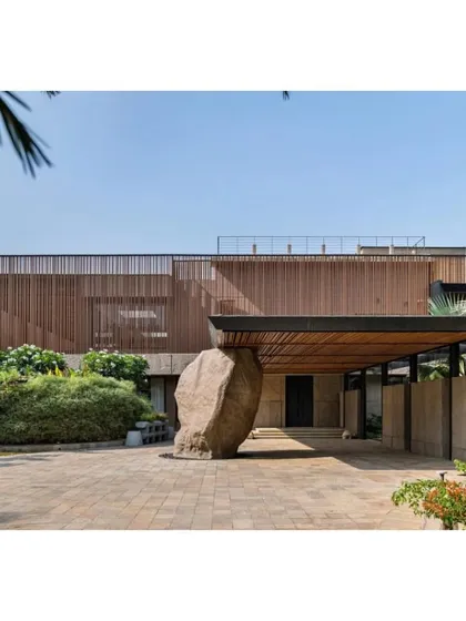 The entrance to the 'K House' is marked by a massive, monolithic rock, creating a powerful and elemental first impression.