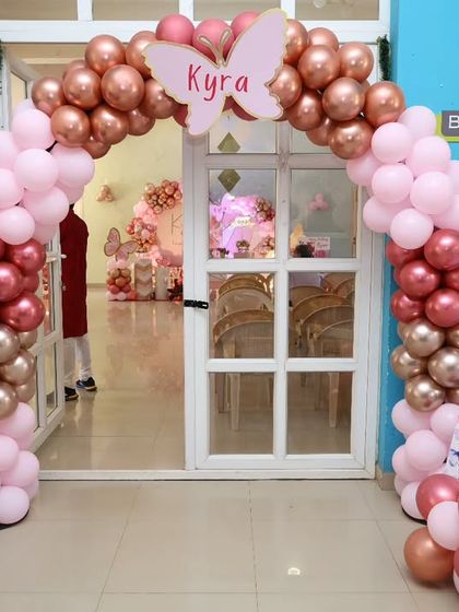 Another view of the elegant rose gold and pink butterfly-themed entrance arch.