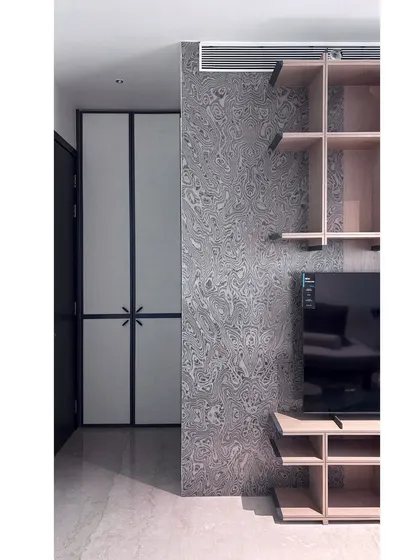 A detail shot of the multipurpose room, showing the textured wallpaper next to the custom shelving unit. The combination of different textures and materials adds depth and character to the space.