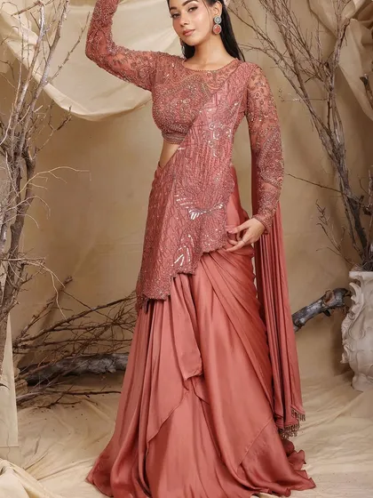 Confidence, stitched with soul. This rose-dust draped lehenga-saree is a beautiful blend of fluidity and structure, featuring a fully hand-embellished bodice for a touch of glamour.