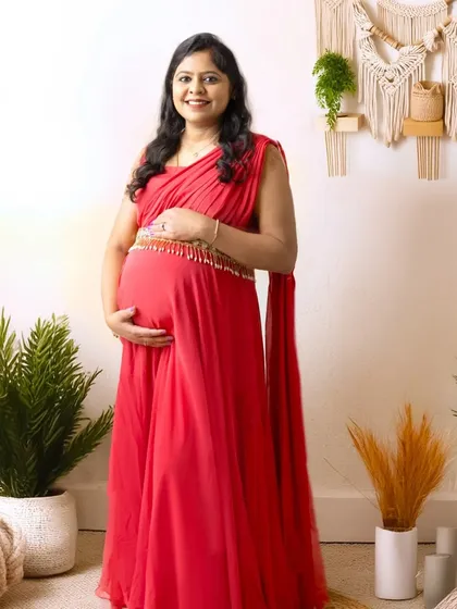 A full-length portrait showcasing a beautiful red maternity gown against a bright, boho-inspired setup. This style is perfect for a modern and chic look.
