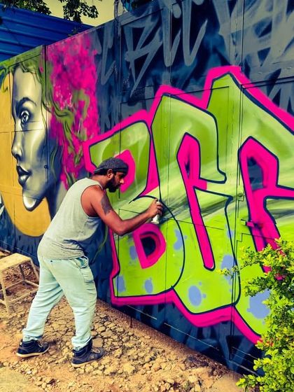 A graffiti artist at work, adding vibrant color to the exterior walls of our space. Our workshops give you the chance to learn these techniques and leave your own mark.