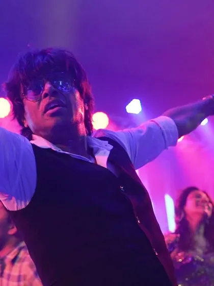 A powerful solo moment on stage, capturing the raw energy of the performance under dramatic lighting.
