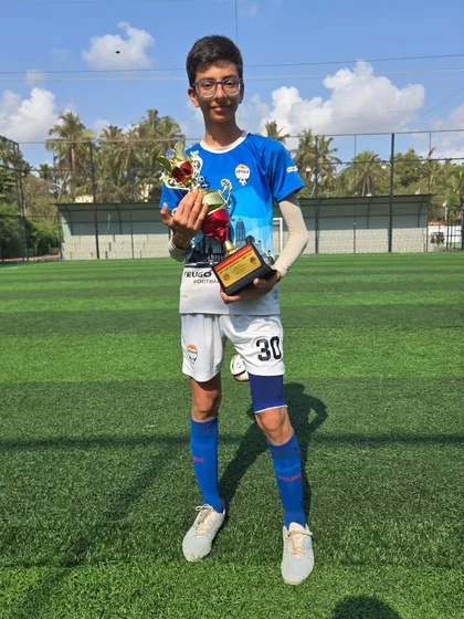 This U14 player proudly displays his team's trophy.