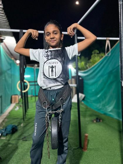 Beauty and strength combined. This young athlete is ready for weighted pull-ups, adding resistance to build next-level power.