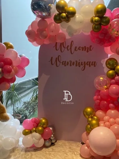 A personalized "Welcome Waniyaa" setup I created for a home celebration. The pink, white, and gold balloon arrangement includes a teddy bear floating on a balloon cloud, making it extra special.