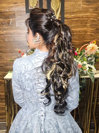 A detailed look at the high ponytail with beautiful curls, a perfect hairstyle for a modern engagement or reception.