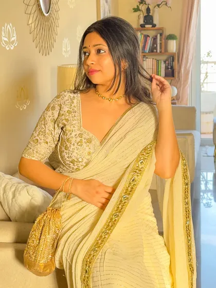 A candid moment in my golden saree look. The light catches the intricate work on the blouse and the delicate texture of the saree, creating a soft, ethereal glow.
