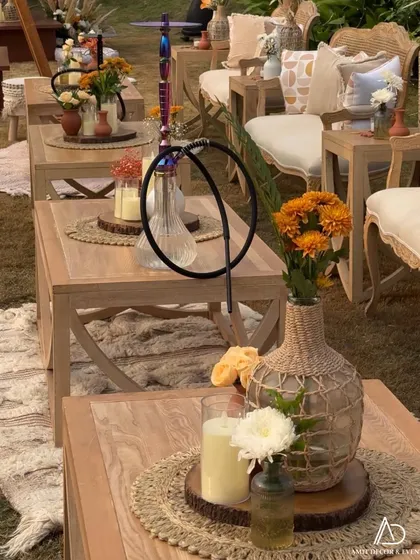 The details make the design. The tables were styled with jute placemats, candles, and simple floral arrangements in rustic vases, with a hookah adding to the relaxed lounge vibe.