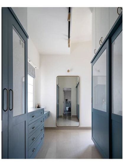 The walk-in wardrobe area in the master bedroom, concealed behind a faux wall. This design provides generous storage while maintaining the room's clean and open feel.