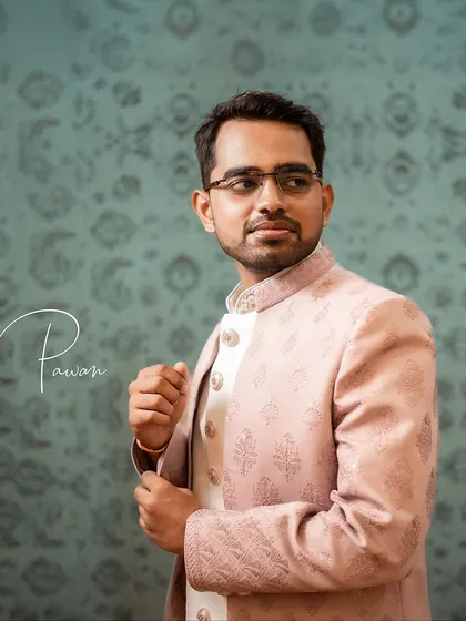 A close-up portrait of the groom, Pawan, adjusting his sleeve. This candid detail shot adds a touch of personality to his portrait session.