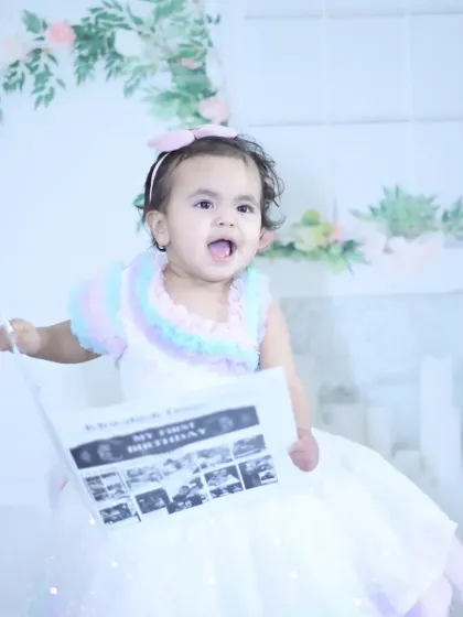 A unique milestone shoot where the baby is holding a custom-made newspaper celebrating their first birthday.