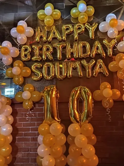 A basic but beautiful birthday decoration with gold and white balloon pillars and "Happy Birthday" foil letters. This is a great budget-friendly option.
