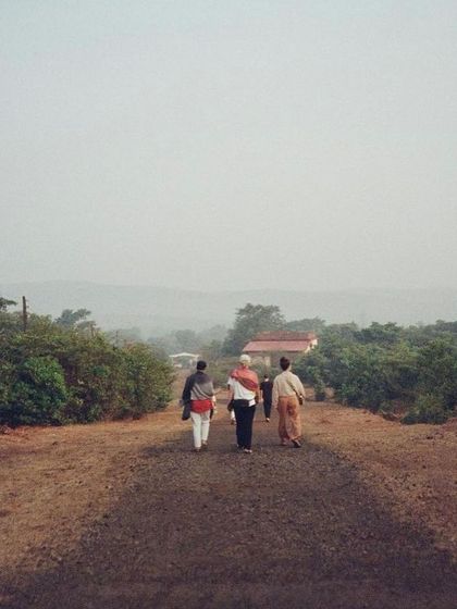 Students and teachers walking along the simple path towards the ashram in Amboli. The journey here is both physical and spiritual, leading to a place of profound learning.