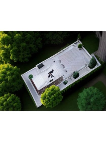 The 'After' shot of a landscaping project. This top-down view clearly shows the finished design with lush green trees and a clean, white rooftop area.