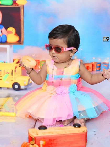 Another playful shot from the Cocomelon session, with the baby girl holding a donut toy. The bright and cheerful set is perfect for fans of the popular show.