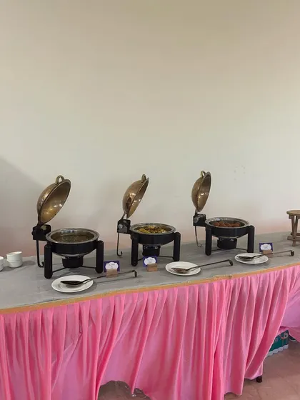 A simple yet elegant buffet setup with a pink table skirt, perfect for a daytime event or a birthday party.