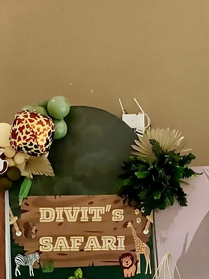 A close-up of the personalized 'Divit's Safari' sign, complete with a monkey cutout and a balloon garland with a leopard-print balloon.