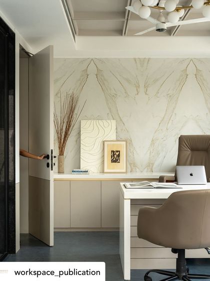 A hand opening the door to the CEO's cabin offers an inviting perspective, drawing the eye towards the elegant marble wall and clean workspace within.