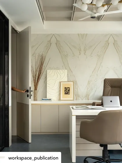 A hand opening the door to the CEO's cabin offers an inviting perspective, drawing the eye towards the elegant marble wall and clean workspace within.