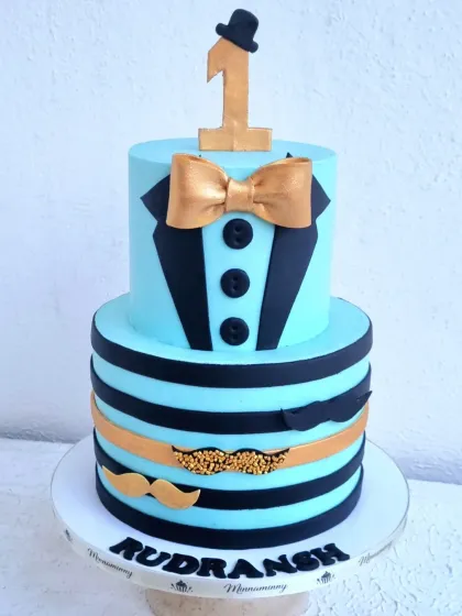 A front view of the "little man" first birthday cake, showing the personalized name on the cake board.