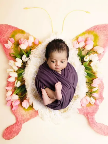 A slightly different pose in the same butterfly theme, showing the baby's cute feet.
