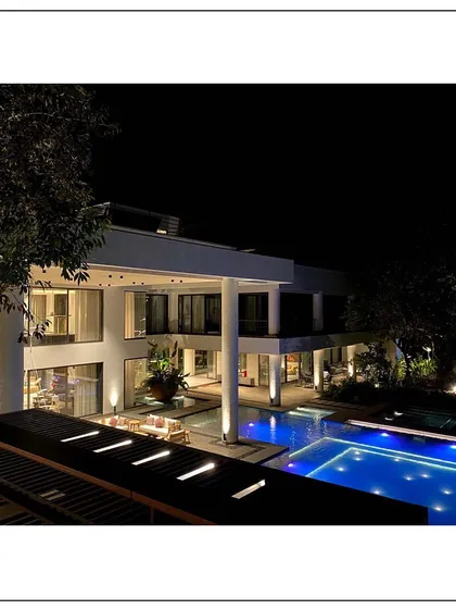 We designed this courtyard-style house in the coastal town of Alibaug to be a modern home engulfed by botanical landscaping. The strategic lighting transforms the space at night, highlighting the pool and creating an easy-going overtone that is perfect for relaxation.