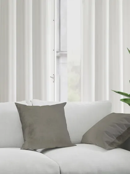A lifestyle shot showing our grey cushions on a white sofa in a well-lit room. This helps customers visualize how your home decor products will look in their own space.