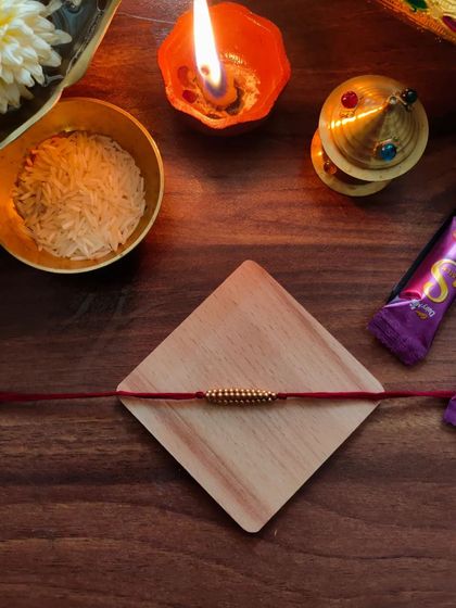 My most affordable rakhi design, priced at 20 rupees. This simple yet beautiful rakhi is made with golden beads on a red thread.