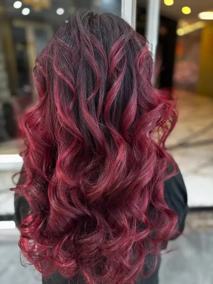 The back view of this red-violet balayage shows the beautiful blend of dark roots and vibrant ends.