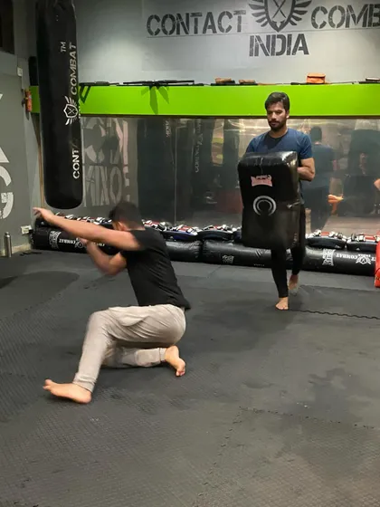 This shows a student practicing getting up from the ground while under threat, a critical survival skill. You must be able to protect yourself and stand up safely.