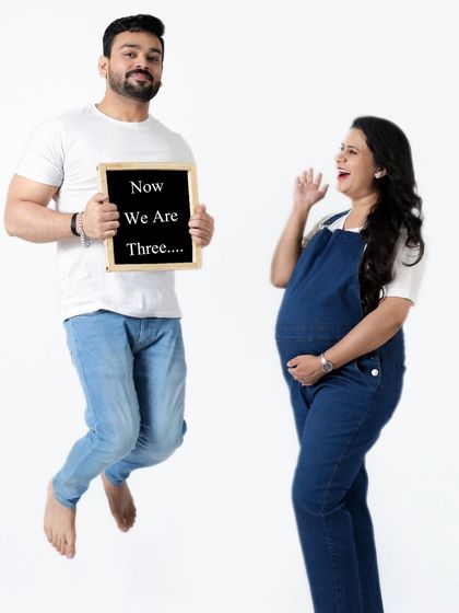 "Now We Are Three." The father-to-be jumps for joy in this fun and energetic pregnancy announcement photo. We love capturing your happiness.