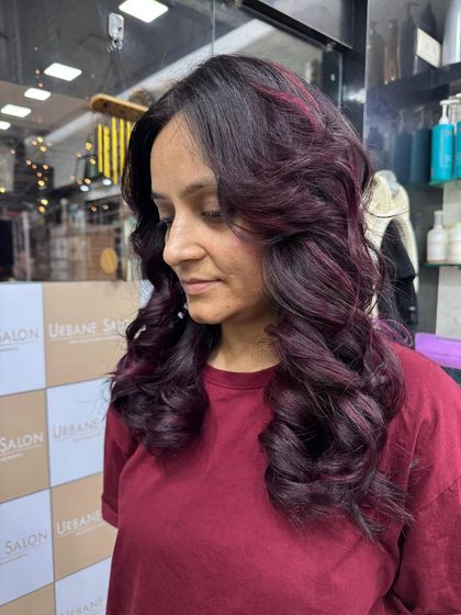 A portrait view of our client looking fabulous with her new Plum Red highlights and a bouncy, voluminous style.