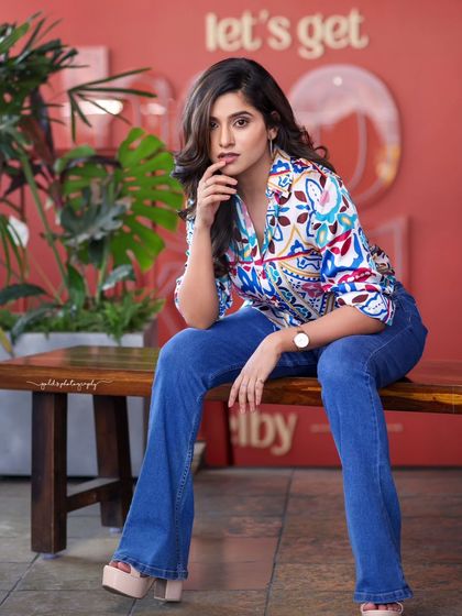 A lifestyle fashion shoot for an actress, featuring a colorful printed shirt and blue jeans. Shot in a modern cafe, these images have a bright, energetic, and youthful feel, perfect for a commercial or social media campaign.