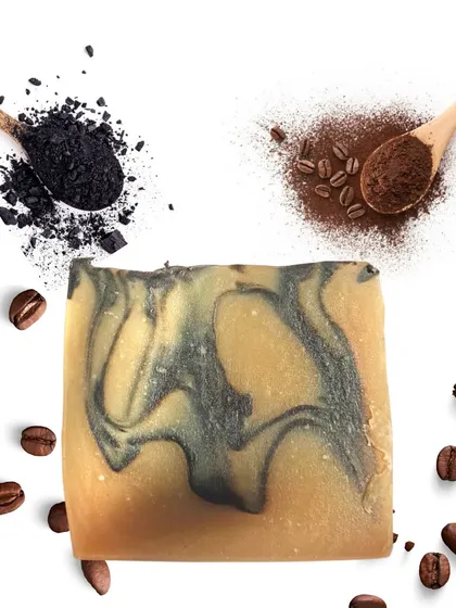 A beautiful shot of my Charcoal Coffee cold-process soap, swirled with activated charcoal and surrounded by coffee beans. This bar is a customer favorite for its ability to gently exfoliate and detoxify the skin, leaving it feeling energized and clean.
