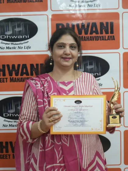 An adult student proudly holds her certificate and trophy.
