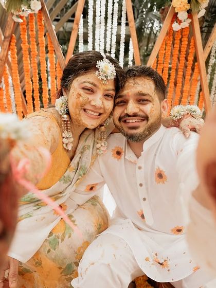 A fun, interactive selfie-style shot from the Haldi. This unique perspective, framed by their henna-covered hands, brings you right into the heart of their joyful celebration.
