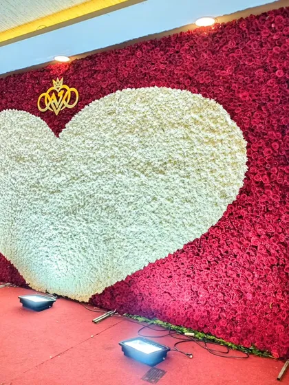 Nothing says "love" quite like a wall of roses. This floor-to-ceiling floral backdrop, featuring a giant heart of white blooms set against a sea of red, creates an incredibly powerful and romantic focal point for any wedding or engagement celebration.