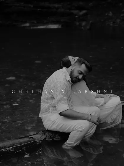 A quiet, soulful moment captured in black and white. The couple sits by the water, lost in their own world. This artistic shot focuses on emotion and the serene, moody atmosphere of the location.