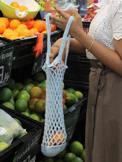 Here’s the crochet market bag in use. It stretches to fit your items and is easy to carry over your shoulder, making it a practical and eco-friendly choice.