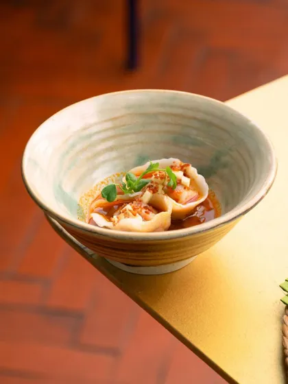 A beautiful shot of our smoked pork and chorizo dumplings in a rustic, handmade bowl, captured during a pop-up event.