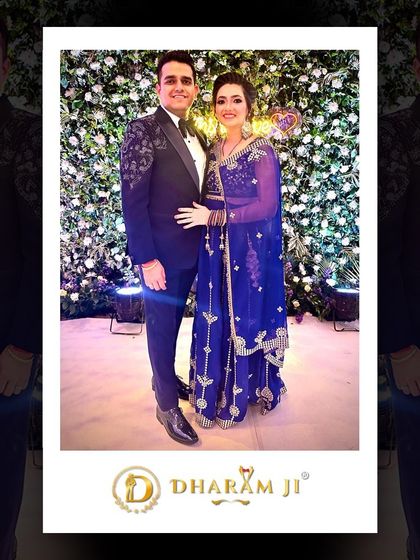 A happy couple at their event. The groom looks dashing in a custom black tuxedo with shoulder embroidery.
