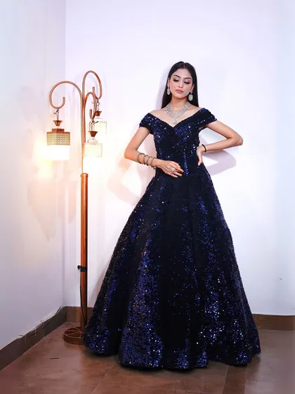 This navy blue sequin ball gown is pure glamour. The off-shoulder neckline and full skirt are perfect for creating a dramatic, high-fashion look.
