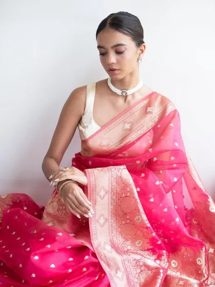 A model shoot featuring a beautiful pink "Gulabi" saree. The makeup is kept fresh and minimal with pink tones, and the hair is styled in a clean low bun with gajra.