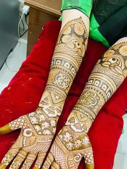 This full-arm mehandi showcases a variety of patterns, including lotus flowers, peacocks, and intricate jaal work, perfect for a bride who wants a rich and detailed design.